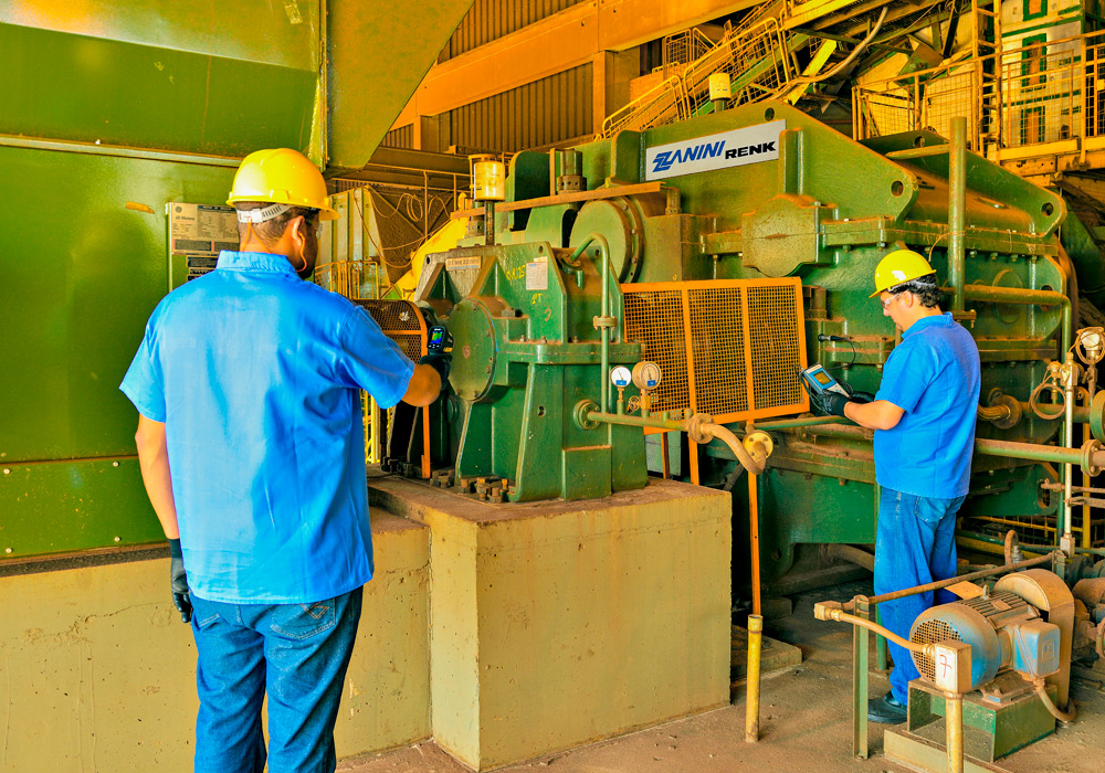 Equipe técnica avaliando equipamentos mecânicos em uma instalação industrial.