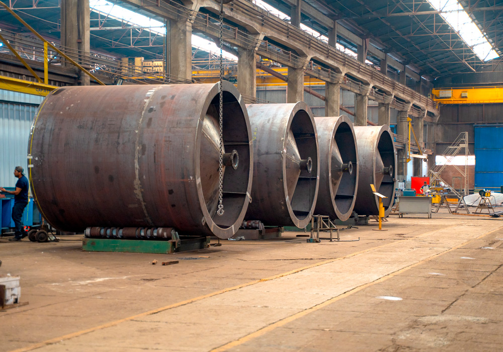 Peças e componentes mecânicos industriais de diferentes dimensões organizados em uma área de fabricação.